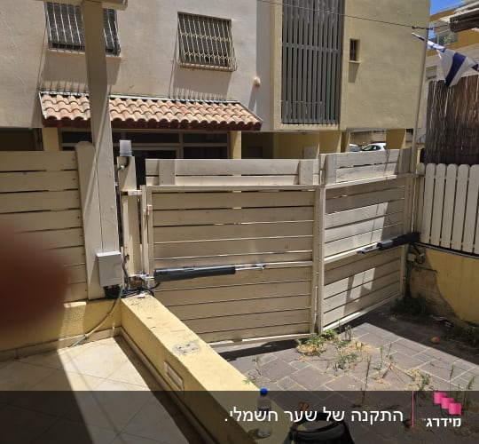 שער עץ חשמלי בעל שתי כנפיים עם מנועי זרוע בחצר בית